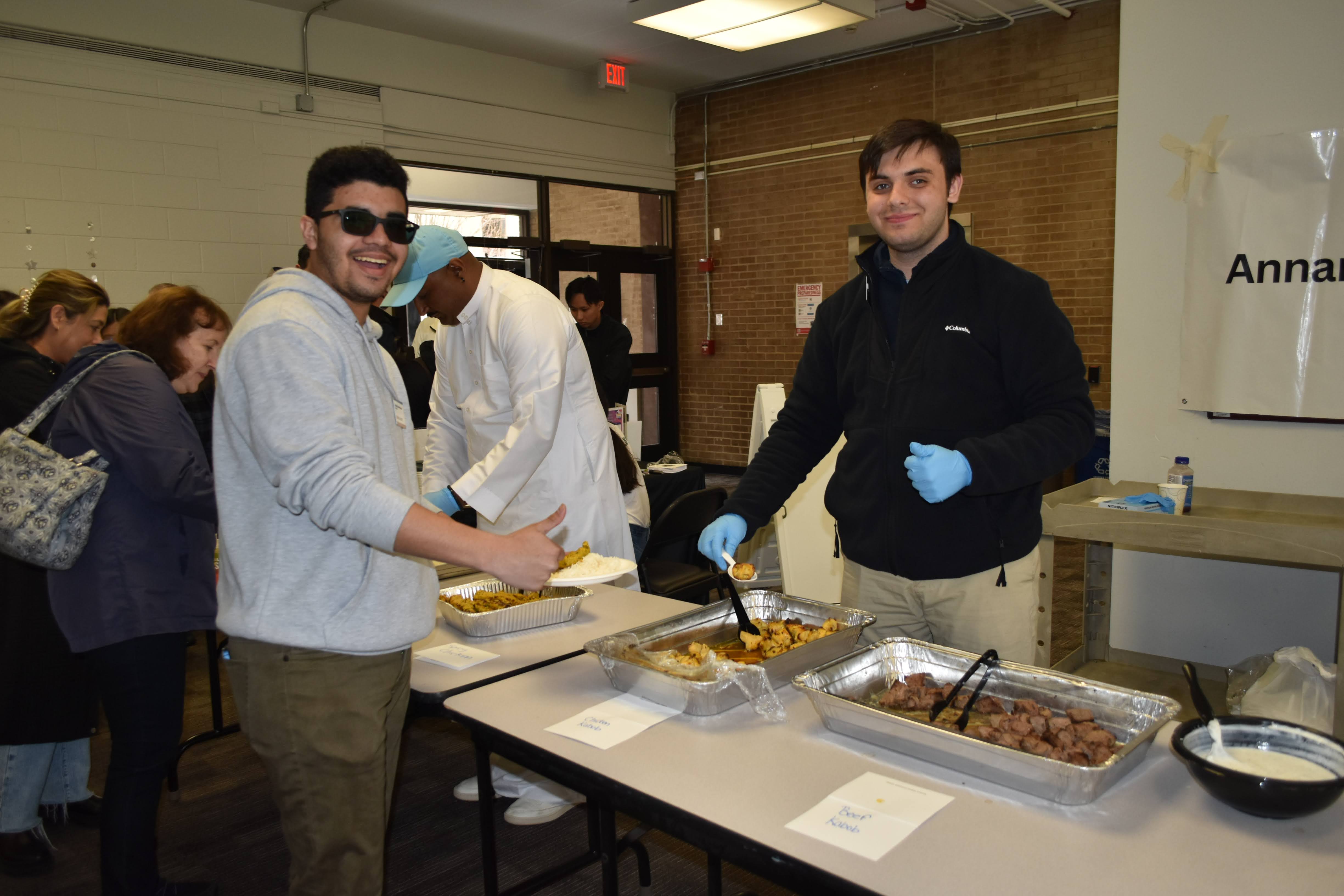Student Life ambassadors serving food at the event.